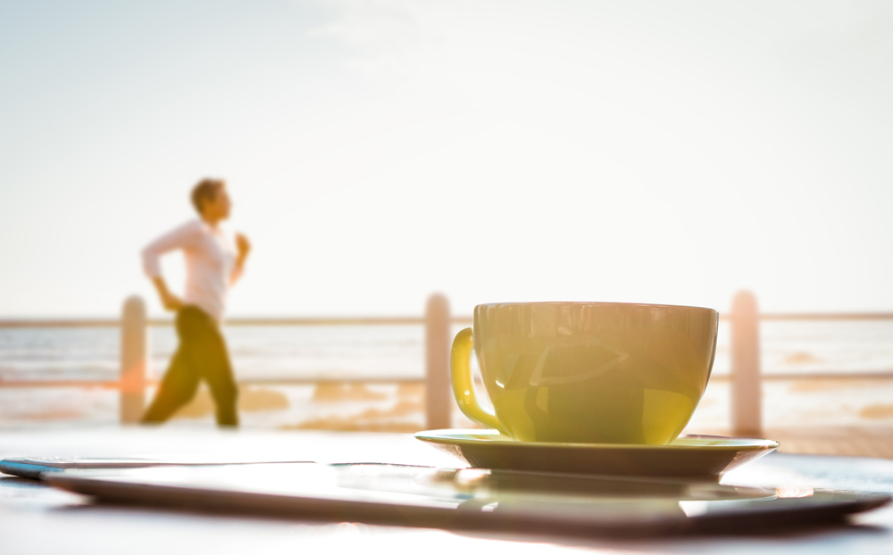 柔らかい朝日の中の白いコーヒーカップ