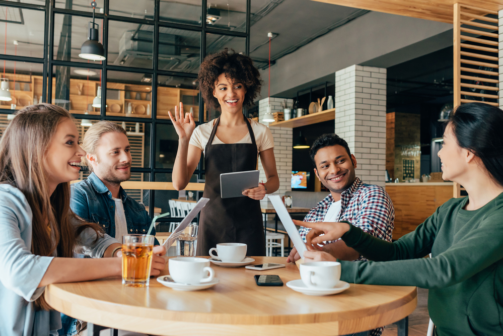 カフェで談笑しながらコーヒーを飲む若者たち